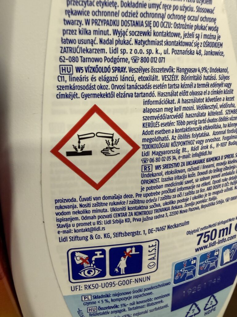 Piktogram ostrzegawczy "substancja żrąca" na etykiecie środka czyszczącego, informujący o ryzyku oparzeń chemicznych skóry i oczu.