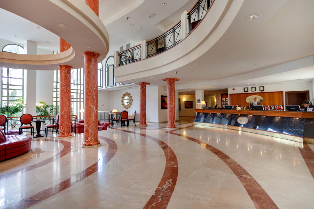 Lobby hotelowe z recepcją i dużą powierzchnią posadzki wymagającą maszynowego czyszczenia
